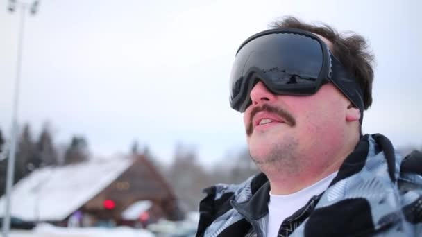 Человек в лыжных очках смотрит в сторону зимы — стоковое видео