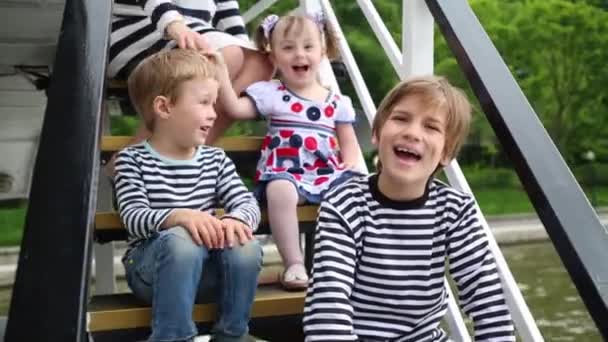 母亲和三孩子坐在游艇的楼梯上 — 图库视频影像