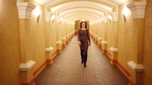 Beautiful curly woman in dress goes in long hallway — Stock Footage Beautiful Curly Woman Dress Goes Long Hallway Royalty Free Stock Footage