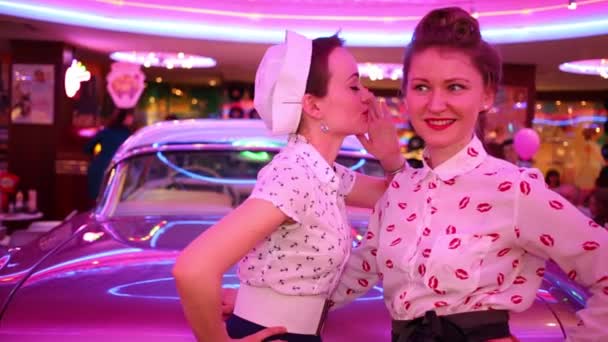 Duas Jovens Mulheres Sussurram Perto Carro Retro Rosa Restaurante — Vídeo de Stock