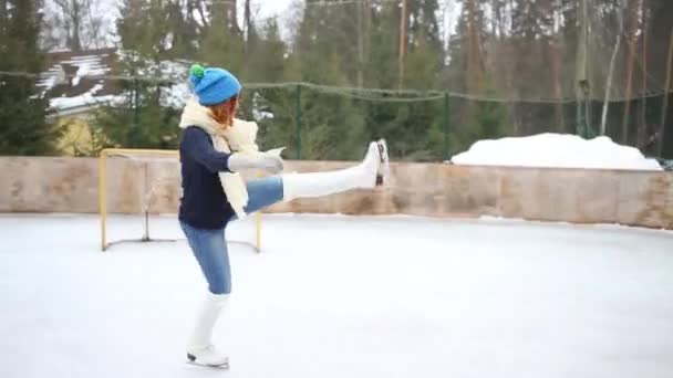 幸せな 代少女の優雅なスケート 冬のアイス スケート場でスピン — ストック動画
