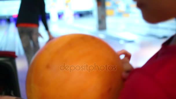 Dívka držící bowlingovou kouli a hledá chlapce házet míč