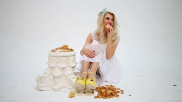 白色的快乐妇女坐在白色地板与糖果 — 图库视频影像