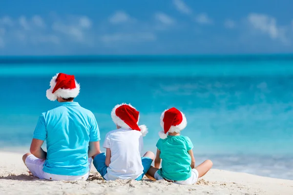 Отец с детьми на пляже на Рождество — стоковое фото