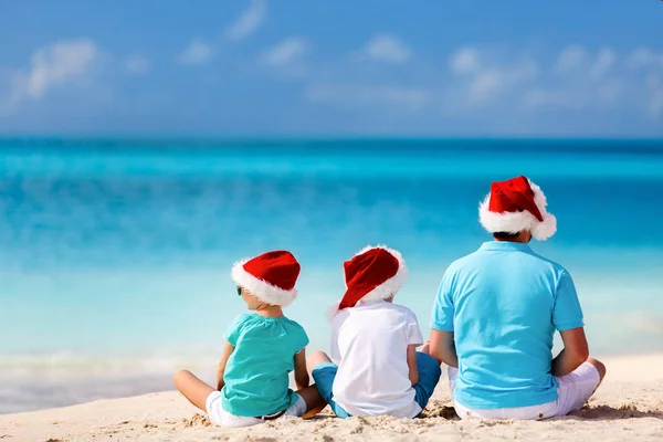 Fadern med barnen på stranden på jul — Stockfoto