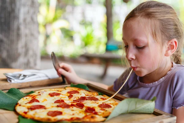 Liten flicka som äter pizza — Stockfoto