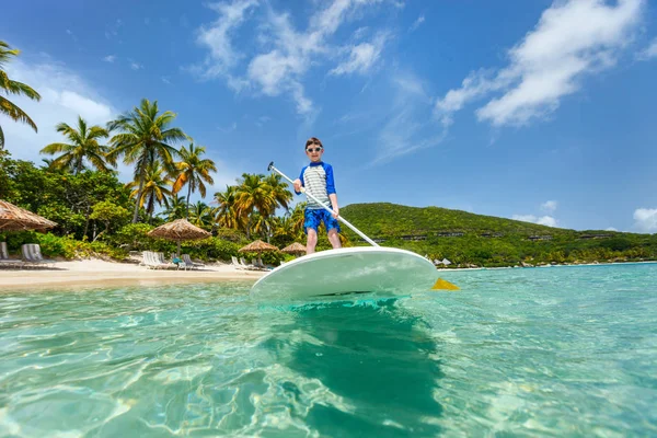 Liten pojke på stå upp paddla ombord — Stockfoto