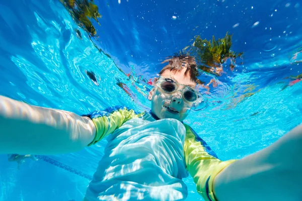 Çocuk suyun altında yüzüyor. — Stok fotoğraf