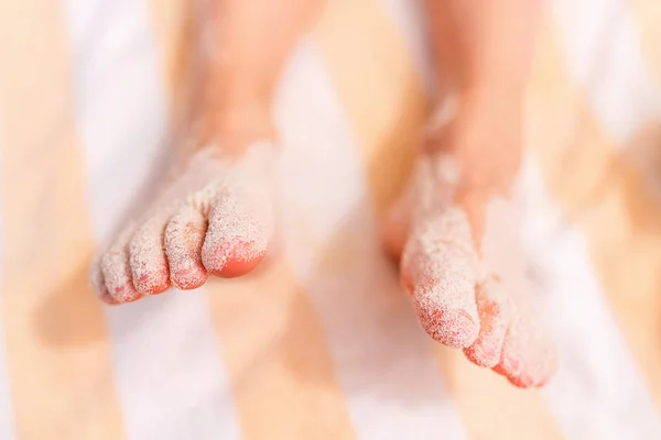 Barnets fötter täcks med sand — Stockfoto