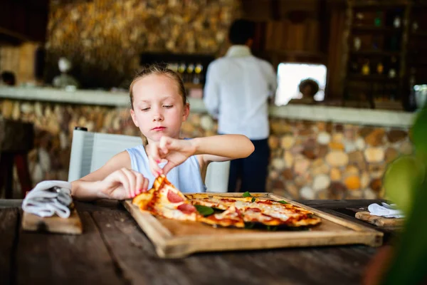 Malá holka jíst pizzu — Stock fotografie