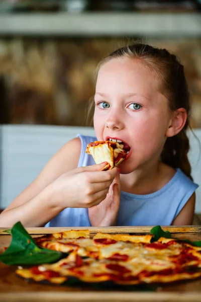 Malá holka jíst pizzu — Stock fotografie