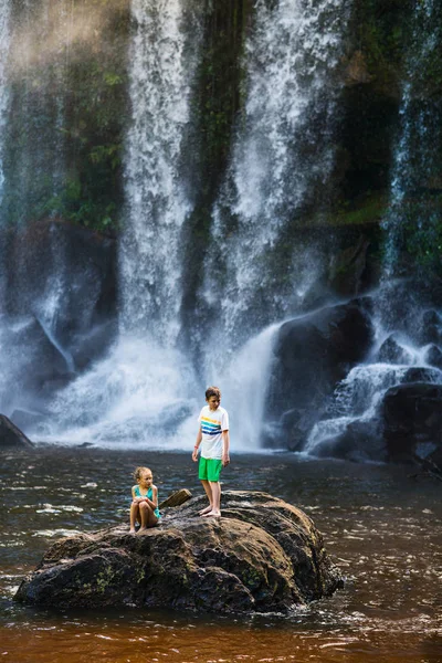Kids swimming in waterfall — Stock Photo, Image