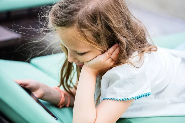 Liten flicka som leker på mobil enhet — Stockfoto