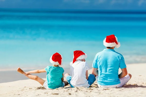 Отец с детьми на пляже на Рождество — стоковое фото