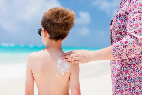 Mãe aplicando creme protetor solar em seu filho — Fotografia de Stock