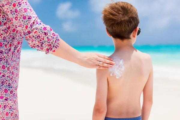 Mor applicera solskydd kräm på hennes son — Stockfoto