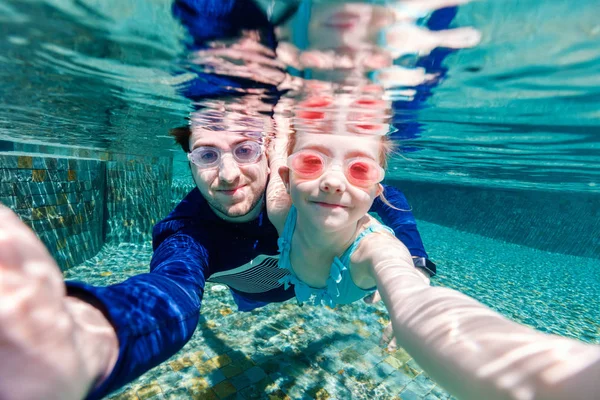 Padre e hija nadando bajo el agua —  Fotos de Stock