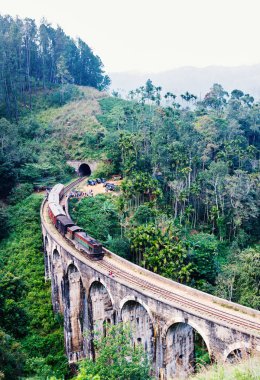 Spectacular view of a train crossing over Nine Arches bridge in Demodara one of the iconic landmarks in Sri Lanka clipart