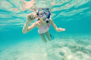 Küçük bir kızın tropikal okyanusta yüzmeye sualtı fotoğraf
