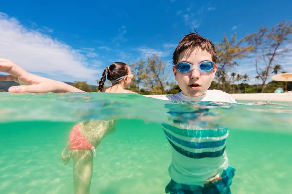 夏の休暇は 浅瀬で一緒に遊んで時に熱帯のビーチで戯れる子供たち — ストック写真