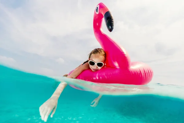夏休みに熱帯海で泳ぐピンクのフラミンゴ インフレータブル リングと愛らしい少女の水中写真を分割します — ストック写真