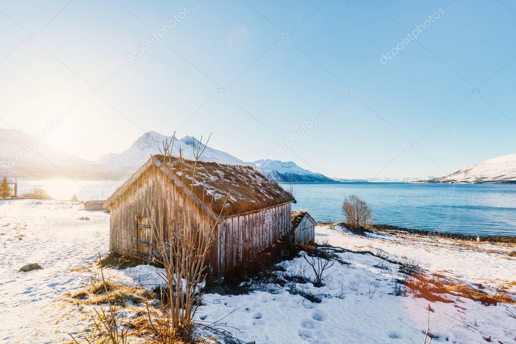 Beautiful winter landscape of Northern Norway with wooden huts overlooking breathtaking fjords scenery