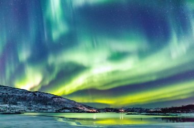 Incredible Northern lights Aurora Borealis activity above the coast in Norway