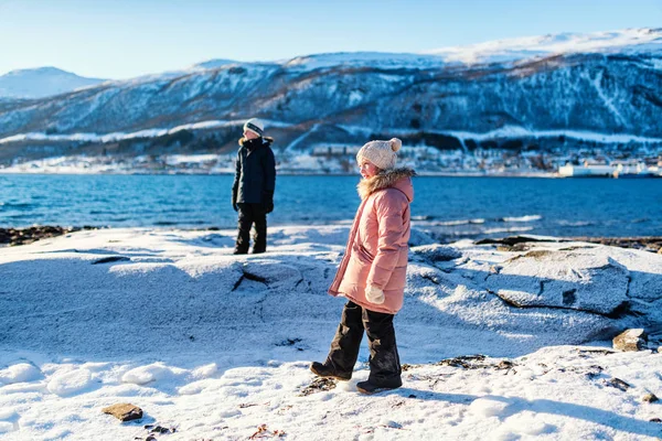 愛らしい少女と屋外北ノルウェーのフィヨルドに囲まれたビーチで雪に覆われた冬の日を楽しむかわいい男の子 — ストック写真