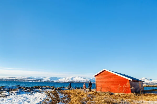 父と北ノルウェーのフィヨルドに囲まれたビーチで屋外雪に覆われた冬の日を楽しむ子供達の美しい家族 — ストック写真