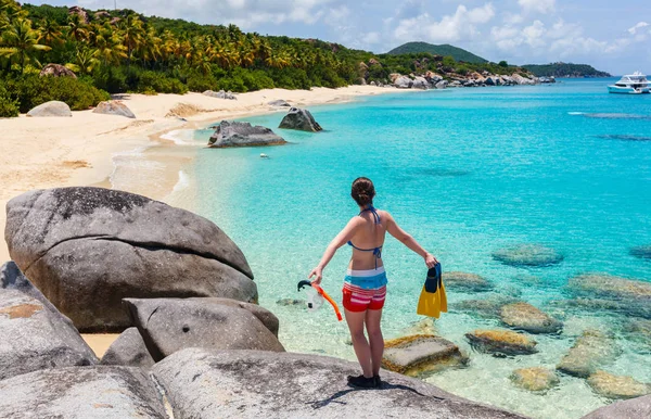 バージン ゴルダ 英領バージン諸島 カリブで花こう岩玉石に立っている熱帯のビーチの眺めを楽しみながらシュノーケ リング用具を持つ若い女 — ストック写真