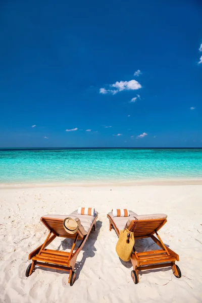 Wooden lounge chairs on a beautiful tropical beach at Maldives