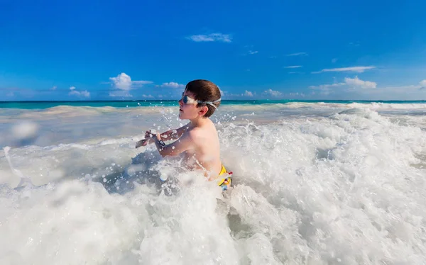 浅水波で遊んで幸せな少年 — ストック写真
