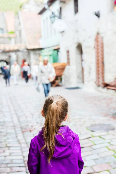 屋外タリン旧市街を探索する愛らしい少女の背面図 — ストック写真