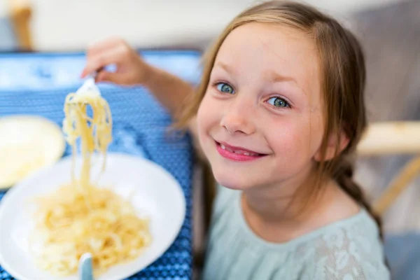 レストランで昼食のためにスパゲティを食べる愛らしい少女の肖像画 — ストック写真