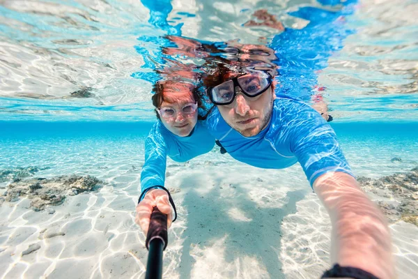 一对夫妇在海洋中浮潜和制作自拍照用棍子的水下照片 — 图库照片