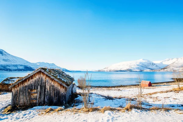 息をのむフィヨルドの風景を望む木の小屋と北ノルウェーの美しい冬の風景 — ストック写真