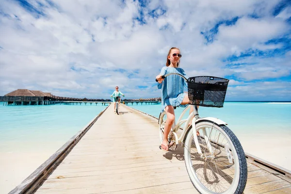 熱帯の海の上に木製の桟橋で自転車に乗る母親と娘のアクティブな家族は 熱帯の休暇を楽しんで — ストック写真