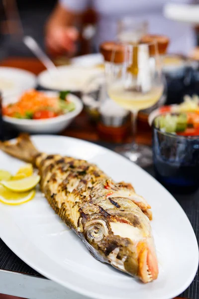 白ワインとランチに提供されるおいしい焼き魚の終わり — ストック写真