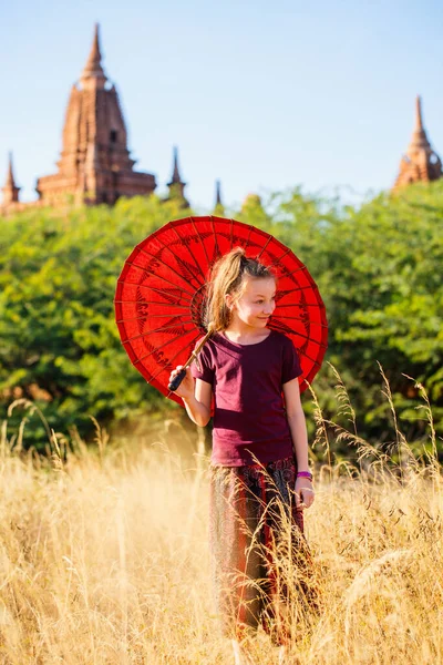 ミャンマー バガンの古代寺院を訪問伝統的なビルマの日傘を持つ少女 — ストック写真