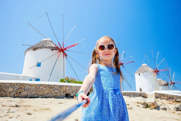 かわいい女の子は ギリシャのミコノス島の人気のある観光地で風車の前に棒で自撮り — ストック写真