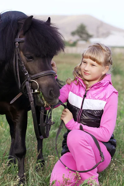 Het meisje en de kleine pony — Stockfoto