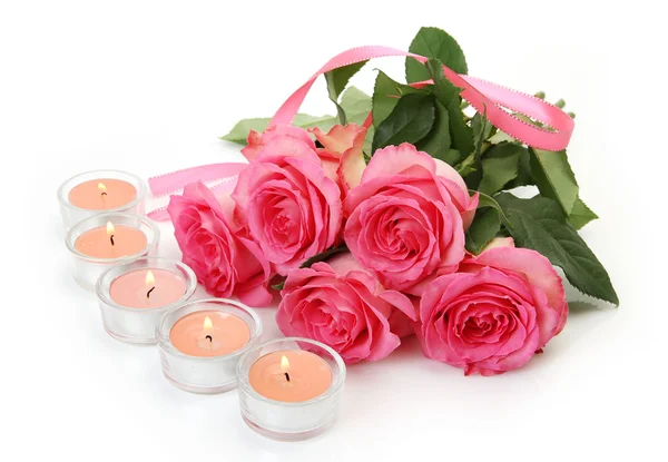 Różowe róże i świece na białym tle — Zdjęcie stockowe