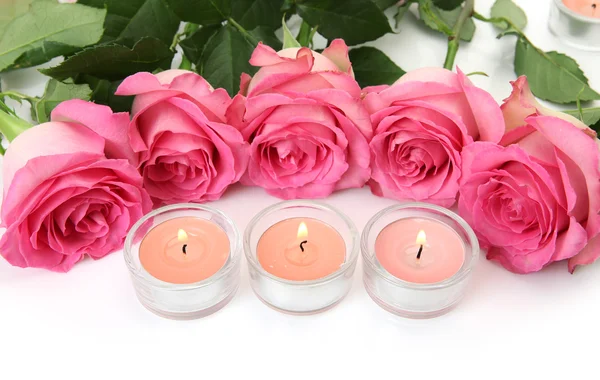Rosas e velas cor de rosa sobre um fundo branco — Fotografia de Stock
