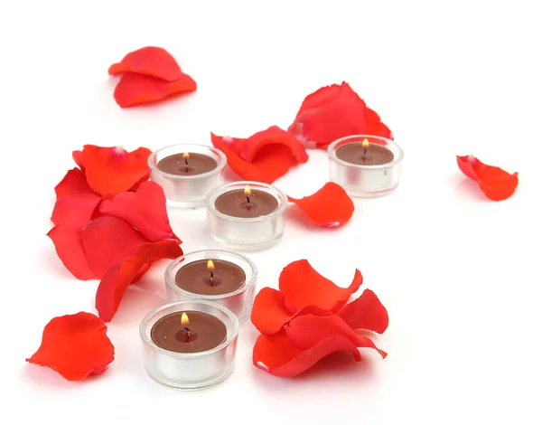 Petals of roses on a white background and candles — Stock Photo, Image