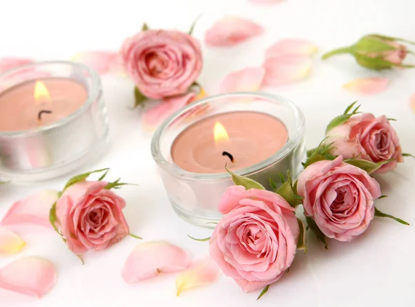 Rosa Rosen und brennende Kerzen — Stockfoto