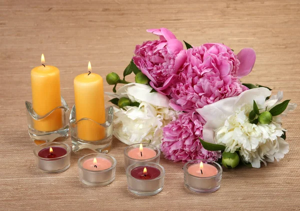 Bouquet di peonie e candele accese — Foto Stock