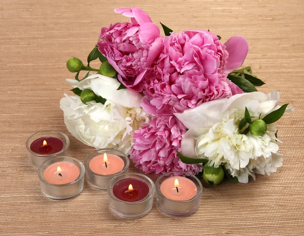 Bouquet di peonie e candele accese — Foto Stock