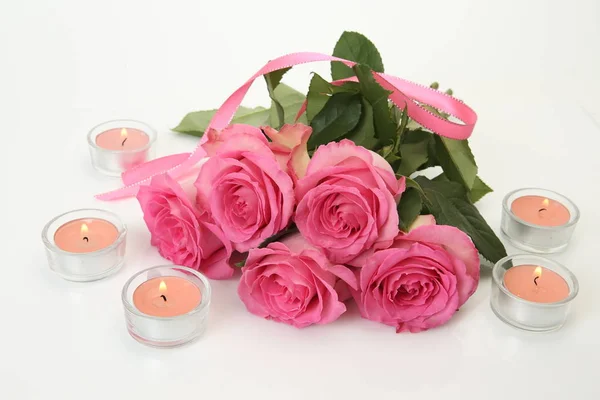 Bouquet of pink roses with candles isolated on white background