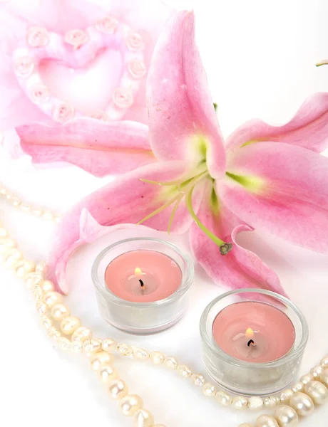 Rosa Lilie und brennende Kerzen — Stockfoto