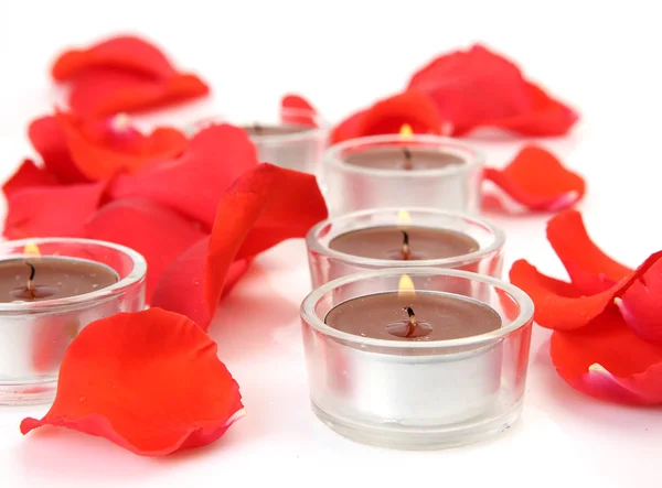 Pétalos rojos y velas encendidas — Foto de Stock